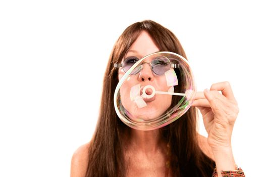 Pretty hippie woman with long hair blowing bubble