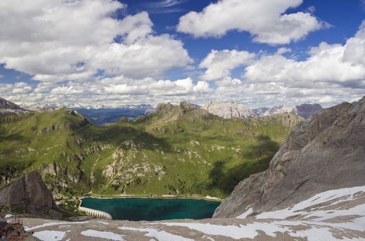 summer view of Fedaia lake and dolomites from Marmolada glacier, Trentino, Italy. Photo taken with polarizer filter