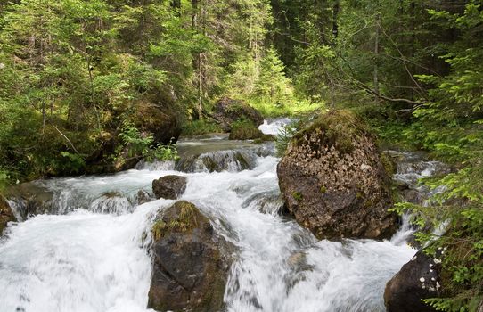 beautiful nature scene with river and waterfall at summer in val di Fassa, italian Dolomites