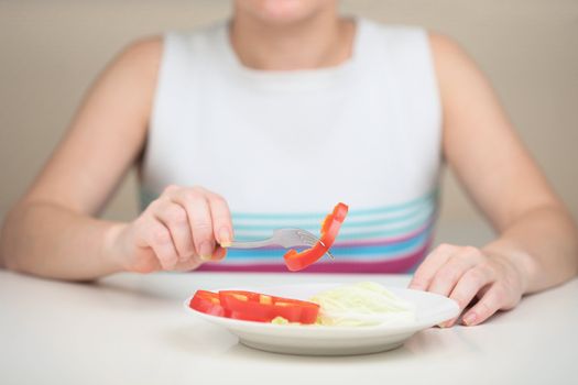 The woman eats vegetables keeping to a strict vegetarian diet