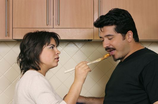 A woman offers pasta to her husband