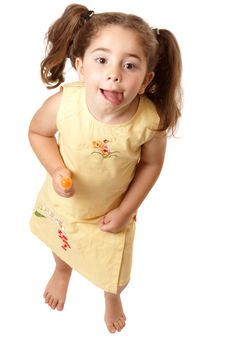 Above view of a young girl child standing  and licking her lips.   