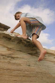 Child clambering over coastal rocks 