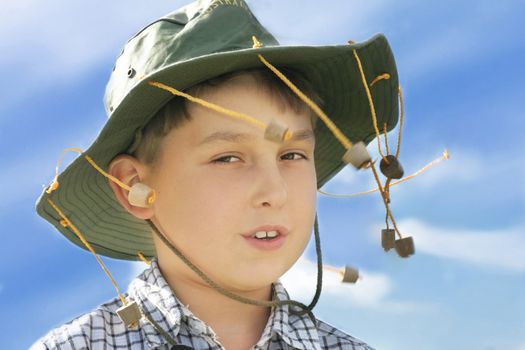 Young country boy with cork hat, blowing in the wind.