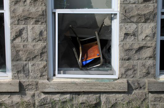 Chair thrown in window by vandals on historic building