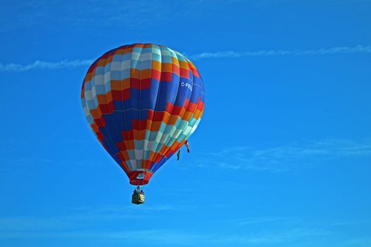 Hot air balloon on blue background with red blue and white highlights.