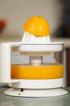 Squeezing of orange juice on a juice extractor