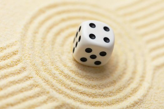 Dice on a sand surface - an abstract art composition in yellow tones