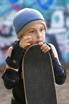 A boy with his skateboard waits his turn