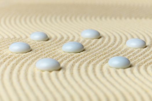 White drops on a surface of yellow sand - an abstract composition