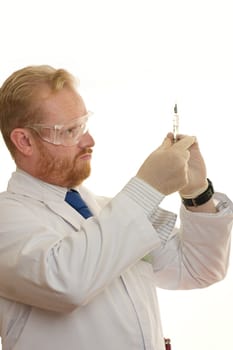 Male doctor in uniform holding a syringe filled with fluid