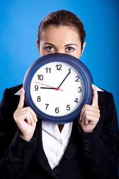 Portrait of a beautiful and young businesswoman holding a clock
