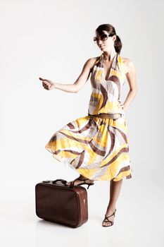 Beautiful fashion woman posing with a vintage suitcase