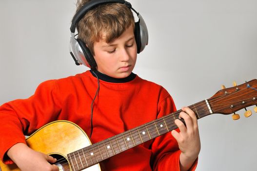 
boy at a rehearsal with headphones, playing guitar