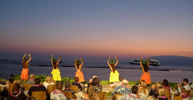 Luau dancers at a dinner performance at a sun set