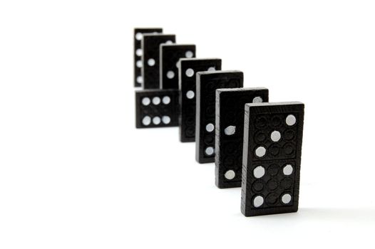 row of dominoes including a special domino stone isolated on white background