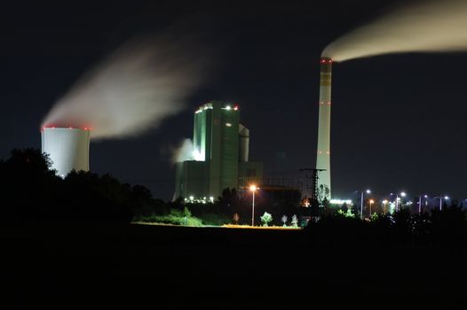 a smoking industrial power plant at night