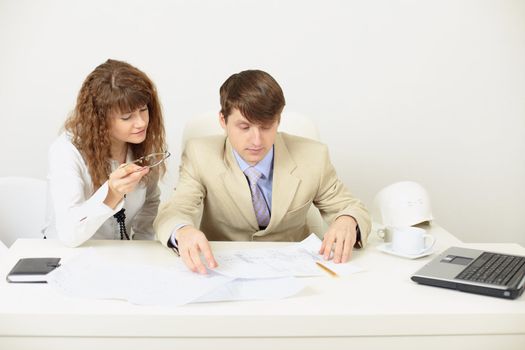 Young engineers plan work sitting at a table at office