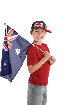 Happy young boy holding an Australian flag and wearing an Australian hat.