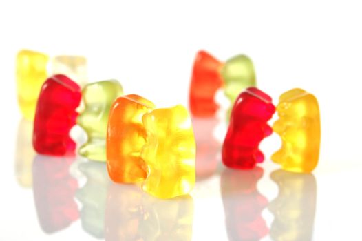 sweet gummy bears dancing on a party on white background