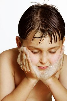 Boy washing his face with soap.