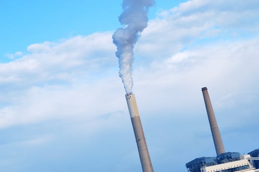 Smokestacks of power station on sky background