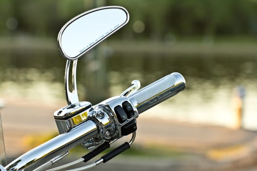 The side mirror and handlebar of a shiny motorcycle