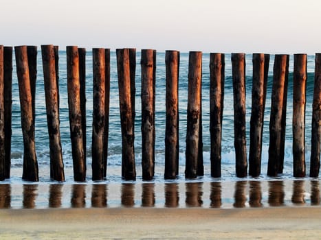 Atlantic ocean beach shore with wooden barrier