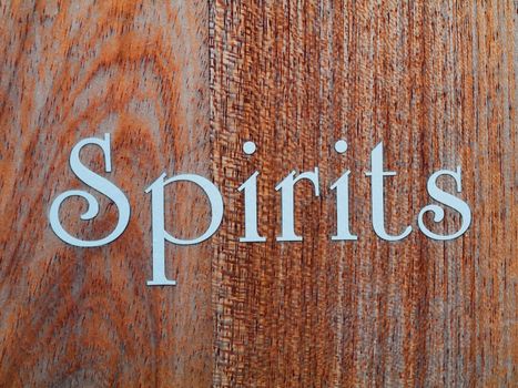 Spirits  in white letter written on wood panel 
