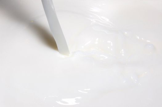 milk splashing into fresh milk with drops