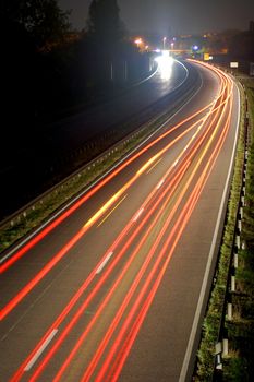 road with car traffic at night and blurry lights showing speed and motion