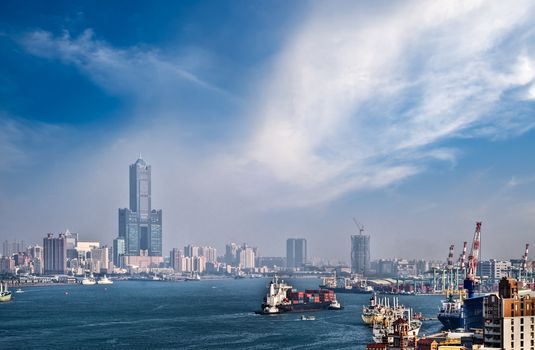 Cityscape of harbor with buildings and boats on the sea in Kaohsiung, Taiwan.