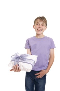 Excited  boy in plain t-shirt and jeans holding a wrapped present ready for birthday or other special occasion.