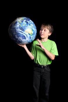 A young boy student looks at the world with amazement and curiosity against a dark background. Slight motion in left hand