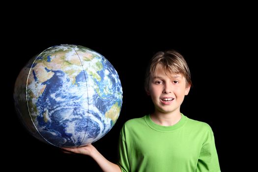 A young boy holding the earth world ball in his hand against a black background.  Images from Nasa.