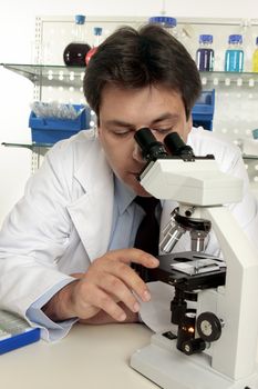 A scientist observing a substance under the microscope.