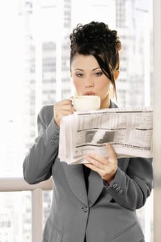 Businesswoman enjoys coffee and newsbreak