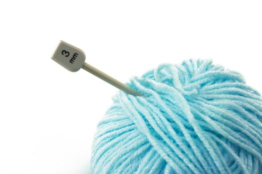 Woollen ball and knitting needle isolated on white