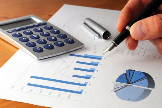 business chart graph or diagram and hand on desktop