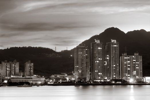 Night scenes of city apartments near the river with beautiful clouds.