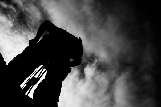 Worker silhouette of photographer stand with dramatic clouds.