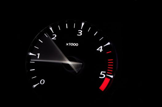 moving revs meter of a sports car on a black background.