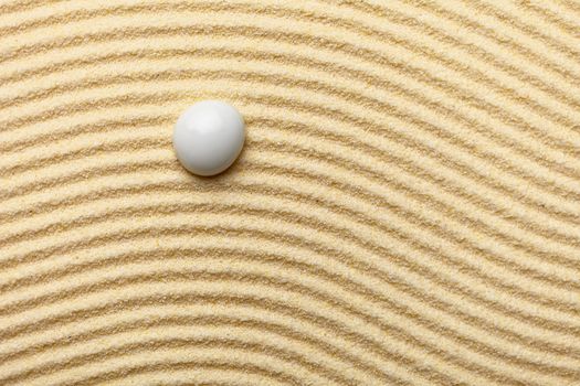 Abstract composition - a sandy wavy yellow background and a glass drop