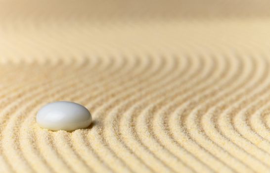 Abstract composition - a sandy yellow background and a glass stone