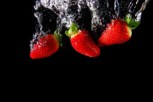 strawberry splashing in water in white background