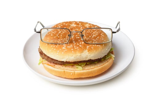 Amusing hamburger in spectacles on a plate isolated on a white background