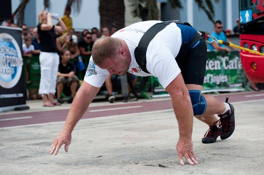 CANARY ISLANDS – SEPTEMBER 03: Lauri Nami from Estonia pulling a double-decker bus behind himself during Strongman Champions League in Las Palmas September 03, 2011 in Canary Islands, Spain