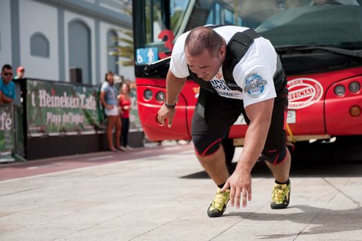 CANARY ISLANDS – SEPTEMBER 03: Akos Nagy from Hungary pulling a double-decker bus behind himself during Strongman Champions League in Las Palmas September 03, 2011 in Canary Islands, Spain