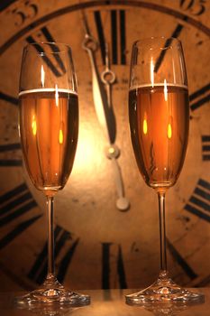 Champagne glasses ready to bring in the New Year with clock 