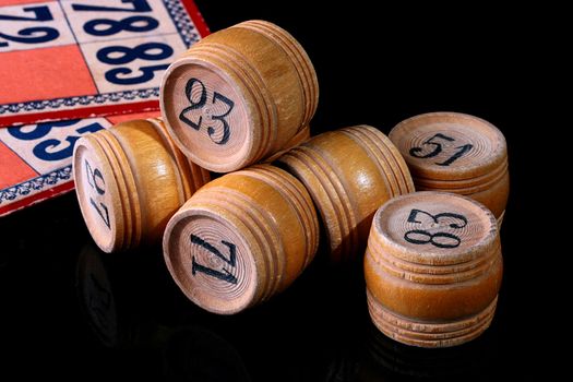 Counters for game in a lotto in the form of kegs and cards for this game on a black reflecting background.